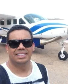 Photo of Leandro in sunglasses standing in front of a plane.