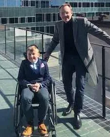 Photo of Sebastien standing next to a child.