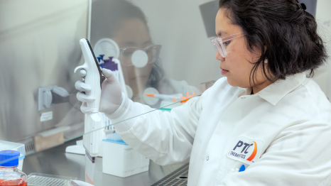 Scientist in a PTC lab coat that is working with a scientific device
