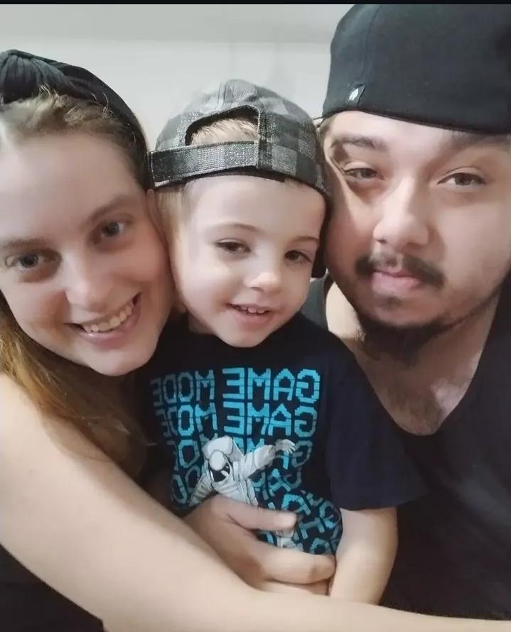 A woman, man, and child smiling